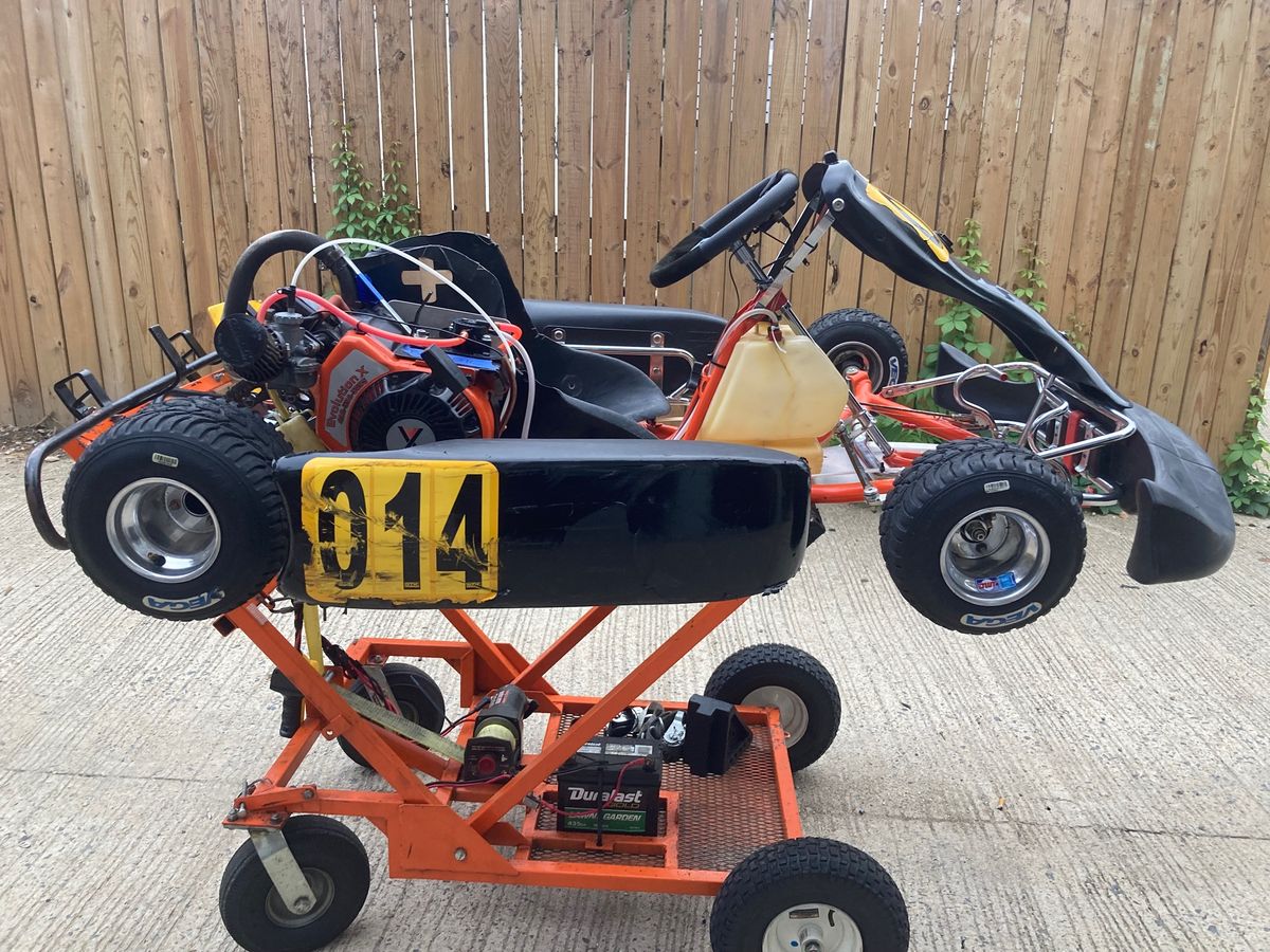 Orange and black go kart on a stand